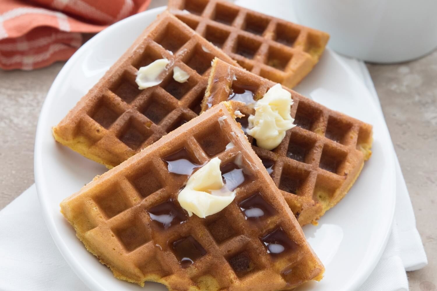 These keto-friendly pumpkin protein waffles are made with organic eggs, pumpkin puree, almond flour, and butter. Our waffles are topped with maple syrup and soft butter. | peteandgerrys.com 