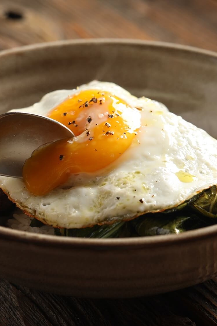 A beef, rice, and egg bowl created by Chef Edward Lee. Flat iron steak is marinated with soy sauce, garlic, and ginger, then seared and served with greens and white rice. Dish is topped with a runny fried egg. | peteandgerrys.com 