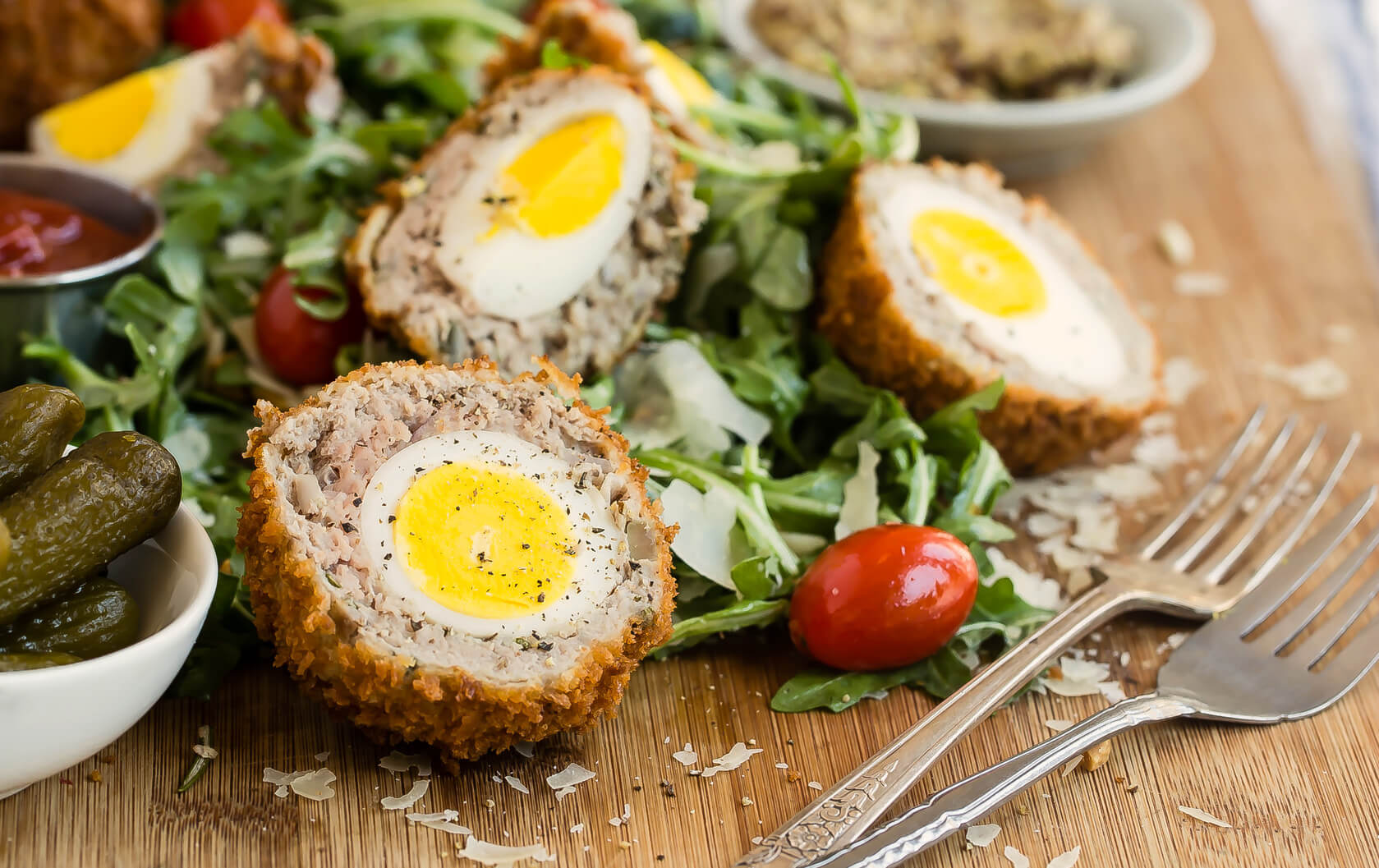 These scotch eggs are a perfect finger food for your next party. This recipe features organic hard-boiled eggs encased in a crunchy mixture of ground pork and panko breadcrumbs and fried to perfection. | peteandgerrys.com 