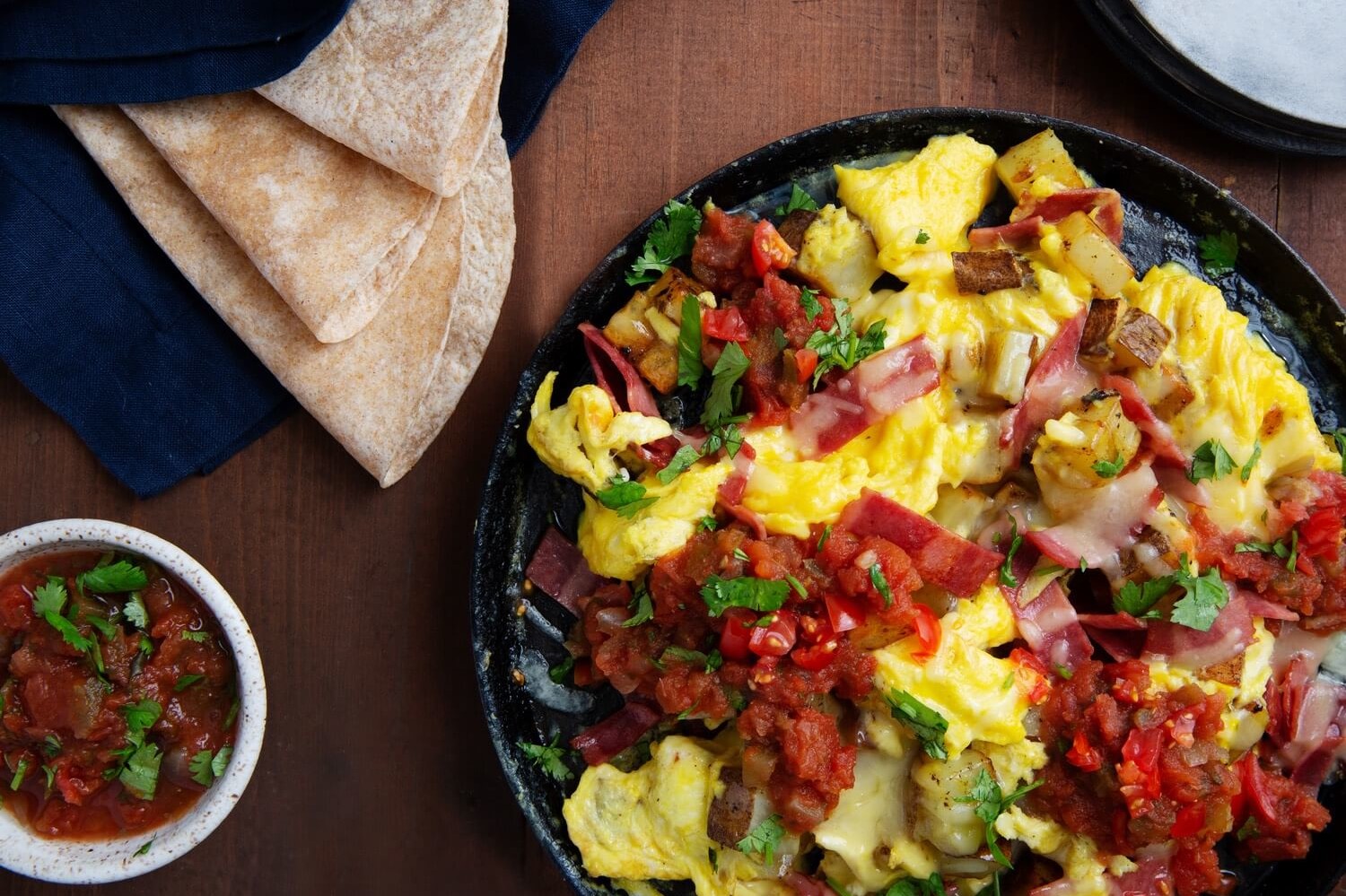 This one pan, texas style potato egg skillet is made with turkey bacon, russet potatoes, pico de gallo, smoked cheddar cheese, and soft tortillas. | peteandgerrys.com 