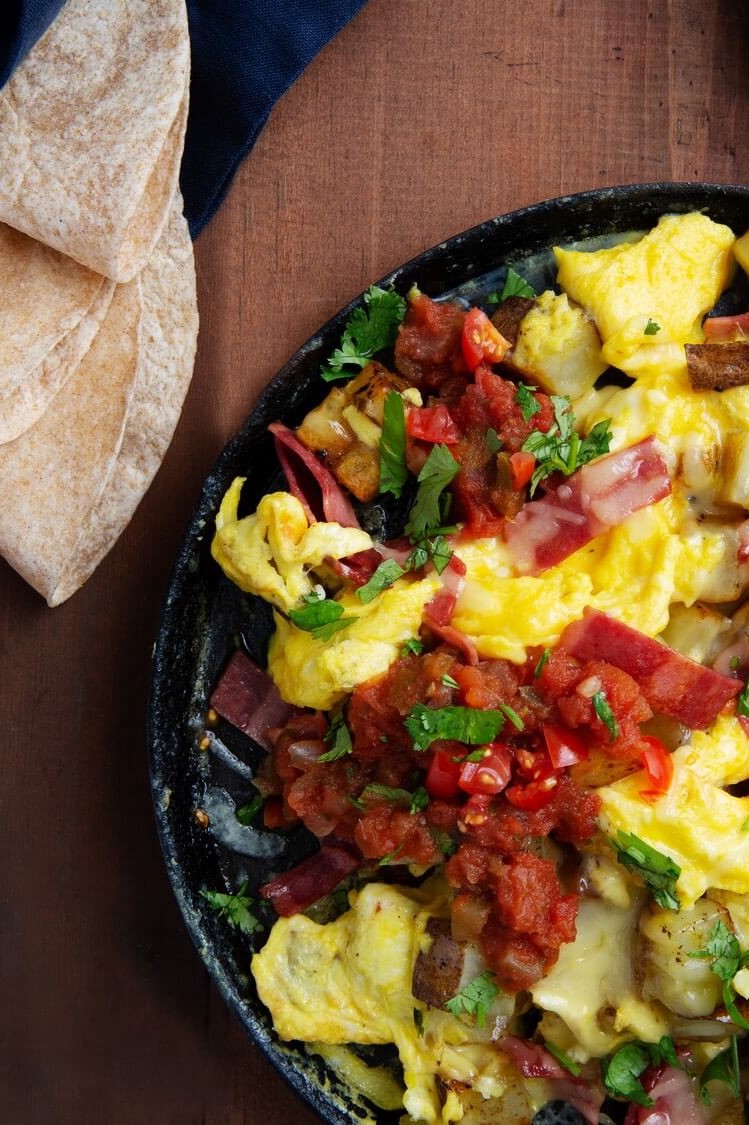 This one pan, texas style potato egg skillet is made with turkey bacon, russet potatoes, pico de gallo, smoked cheddar cheese, and soft tortillas. | peteandgerrys.com 