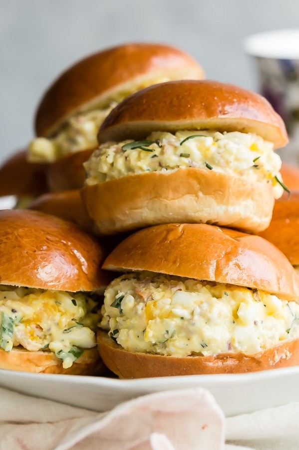 This classic egg salad is elevated by adding mix-ins like chopped bacon, green onion, and fresh rosemary. We served our organic egg salad in golden brioche rolls. | peteandgerrys.com 