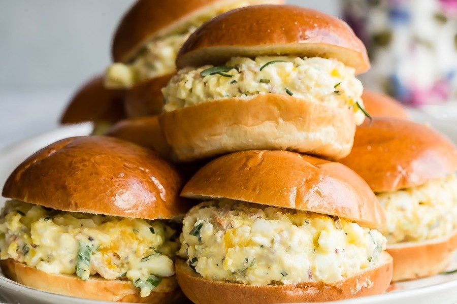 This classic egg salad is elevated by adding mix-ins like chopped bacon, green onion, and fresh rosemary. We served our organic egg salad in golden brioche rolls. | peteandgerrys.com 