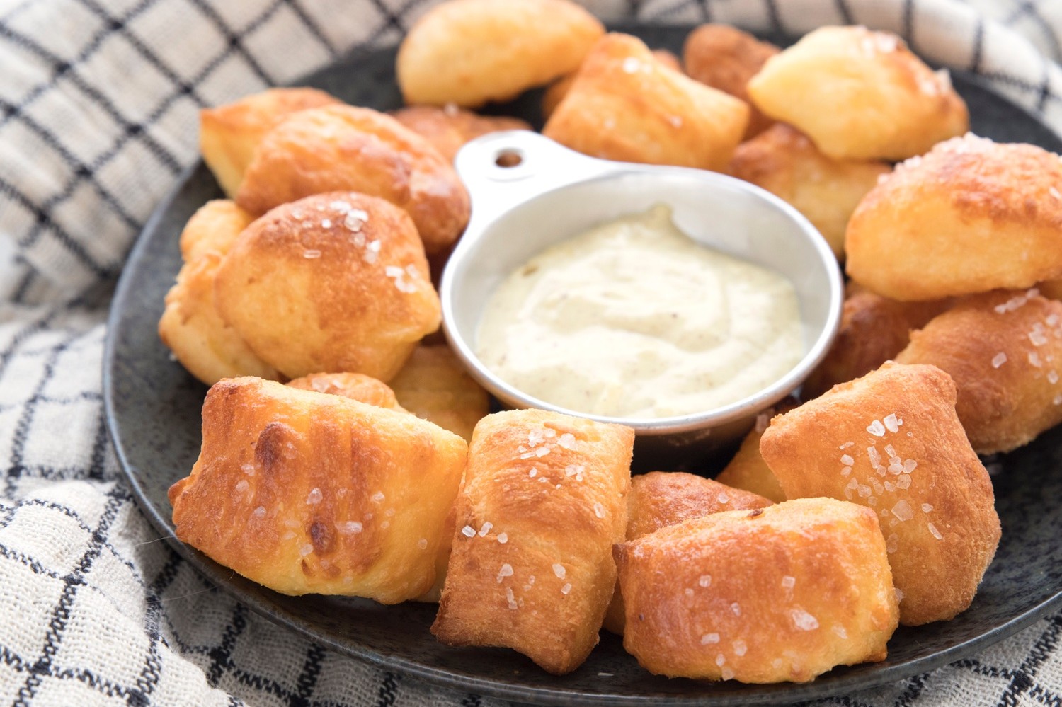 Pretzel bites made with keto fathead dough served on a plate with creamy mustard dip. 