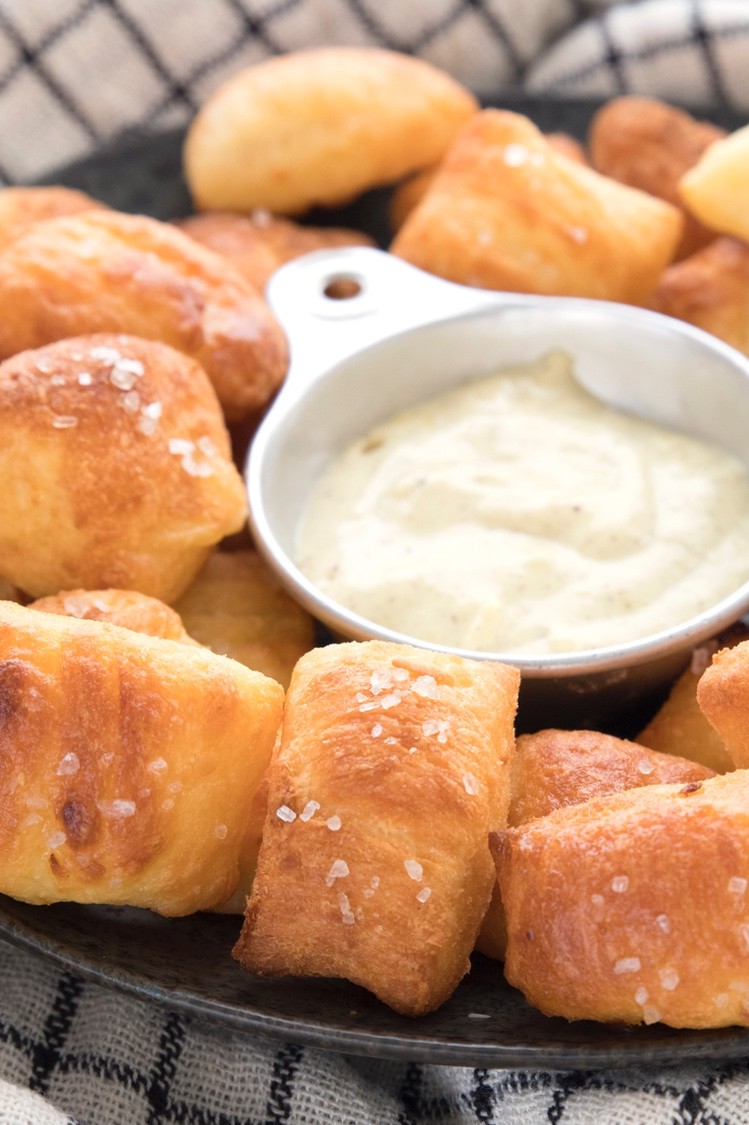 Pretzel bites made with keto fathead dough served on a plate with creamy mustard dip. 