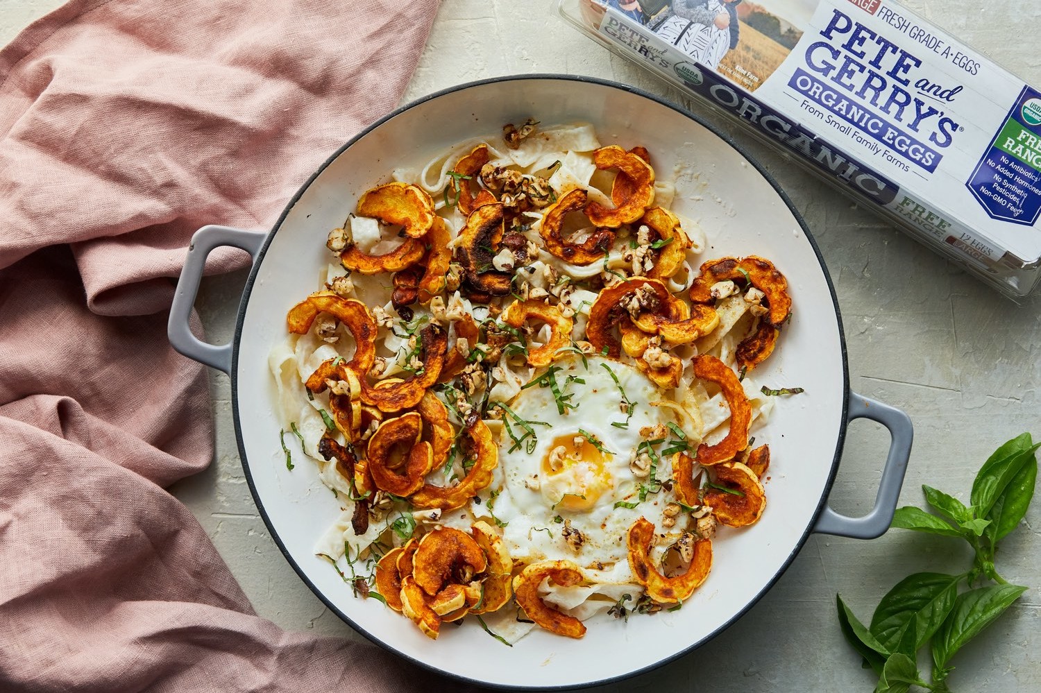 Creamy delicata squash pasta tossed with an easy goat cheese sauce, roasted delicata squash, Pete and Gerry's fried organic eggs, basil, and maple-hazelnuts. 