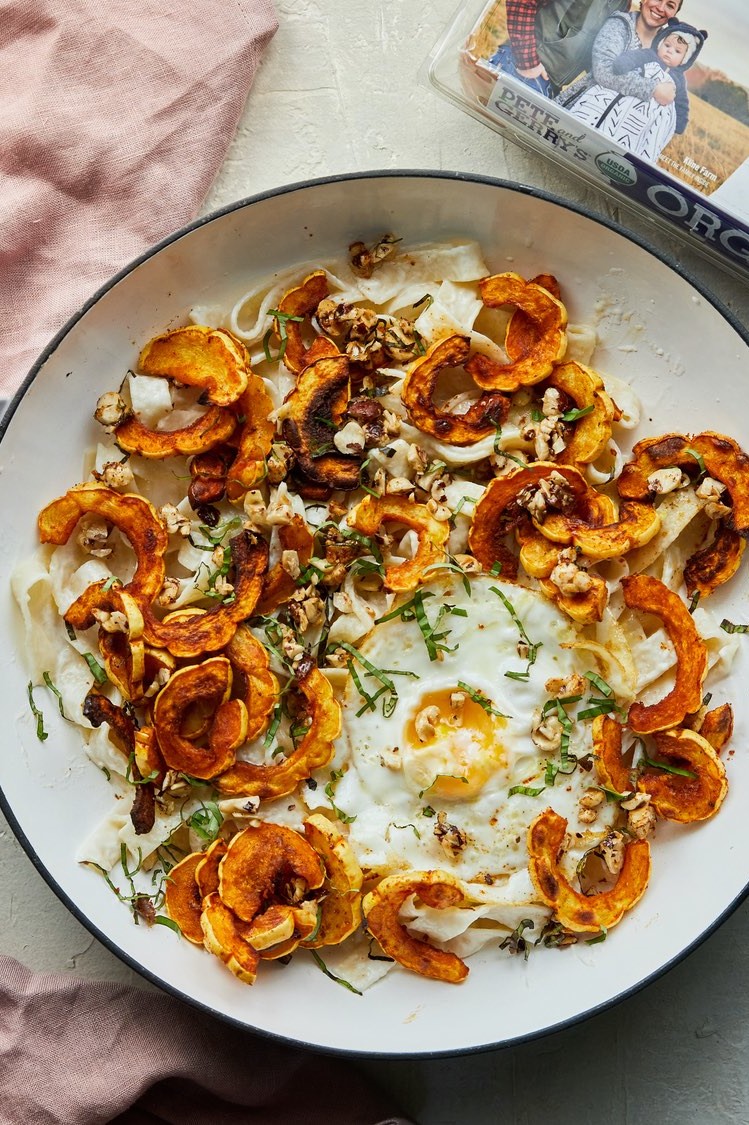 Creamy delicata squash pasta tossed with an easy goat cheese sauce, roasted delicata squash, Pete and Gerry's fried organic eggs, basil, and maple-hazelnuts. 