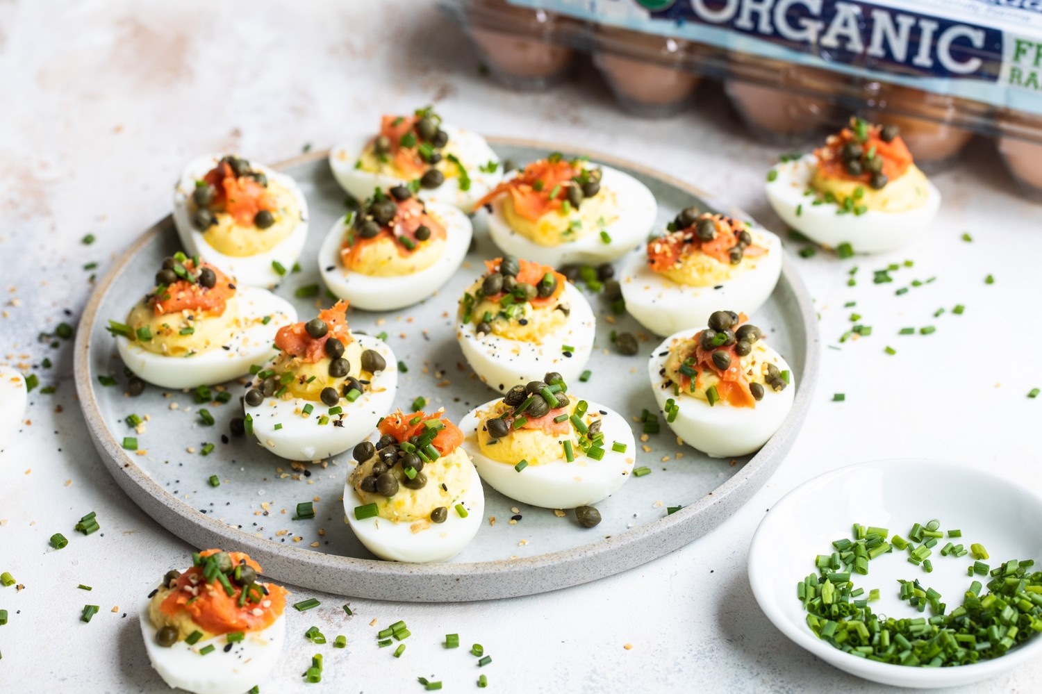 These deviled eggs are filled with a smooth yolk, mayo, crème fraîche, and chive mixture. Then finished with delicate slices of smoked salmon, capers, more chives, and of course, everything bagel seasoning.