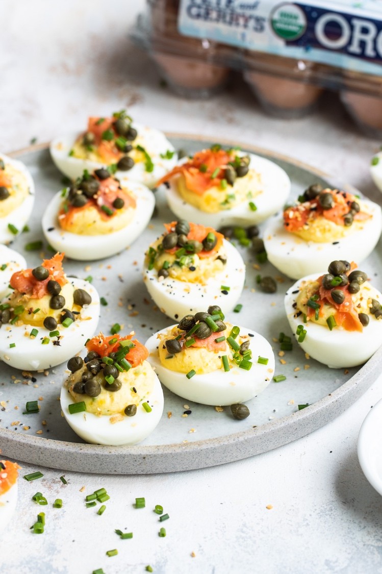 These deviled eggs are filled with a smooth yolk, mayo, crème fraîche, and chive mixture. Then finished with delicate slices of smoked salmon, capers, more chives, and of course, everything bagel seasoning.