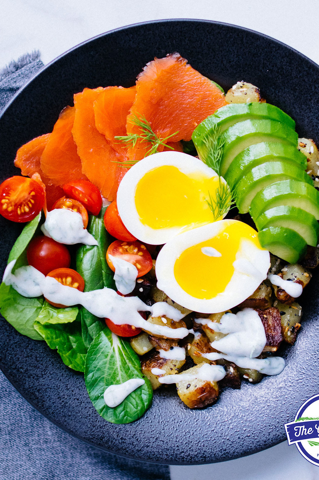 This soft boiled egg and smoked salmon bowl is a perfect healthy lunch. At the center of the picture, there's runny soft boiled organic eggs, cucumber slices, spinach, and salmon. | peteandgerrys.com 