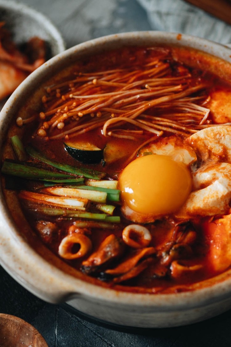 Sundubu jjigae (also known as Korean spicy soft tofu stew) made with a traditional combination of gochugaru, kimchi, pork, seafood, mushrooms, and a Pete and Gerry's Organic Egg yolk.